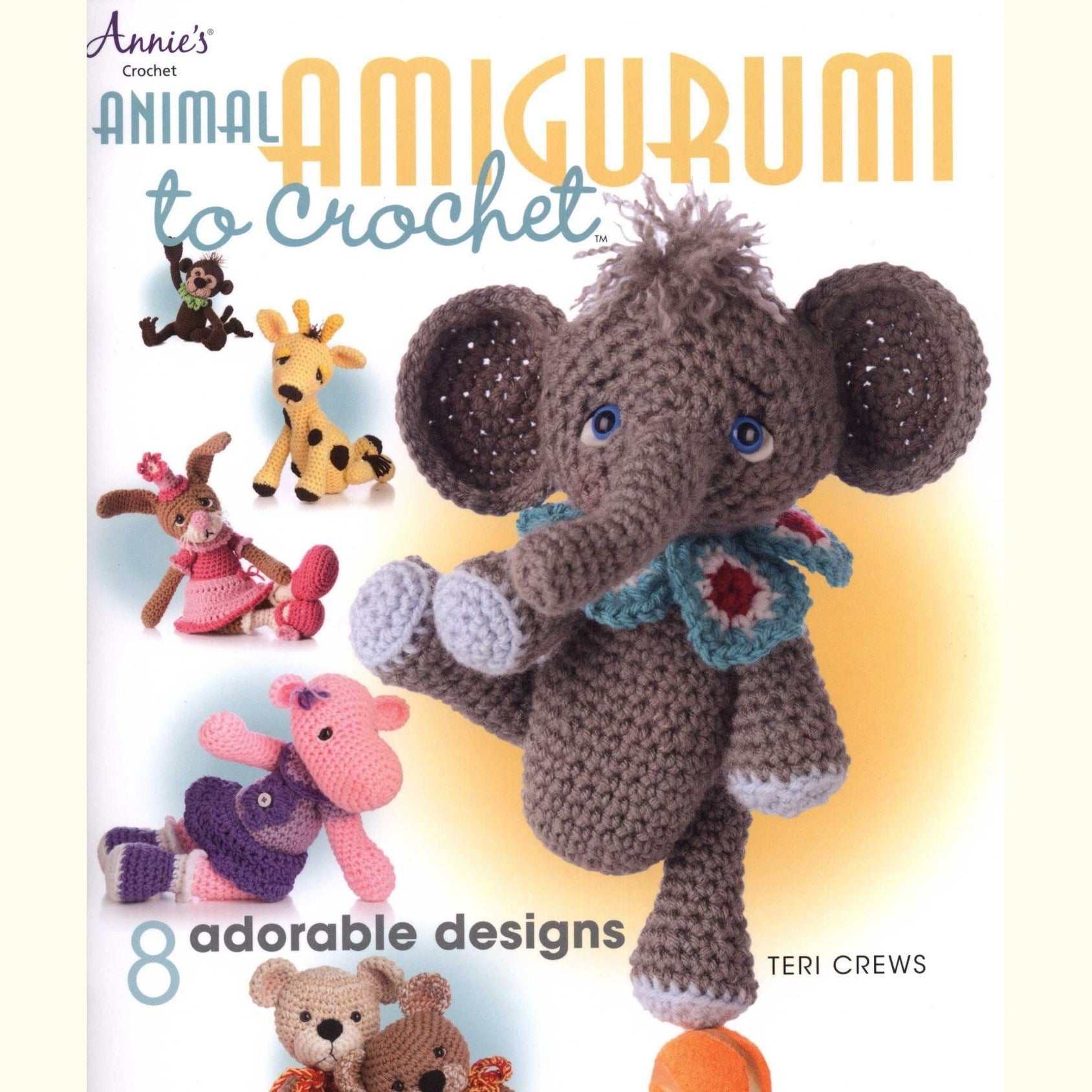 Crochet elephant amigurumi with blue scarf and flower, small giraffe, bear, and pink animals in background.