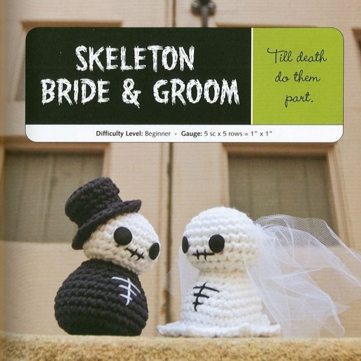 Skeleton bride and groom amigurumi crochet dolls with black top hat and white veil on wooden background.