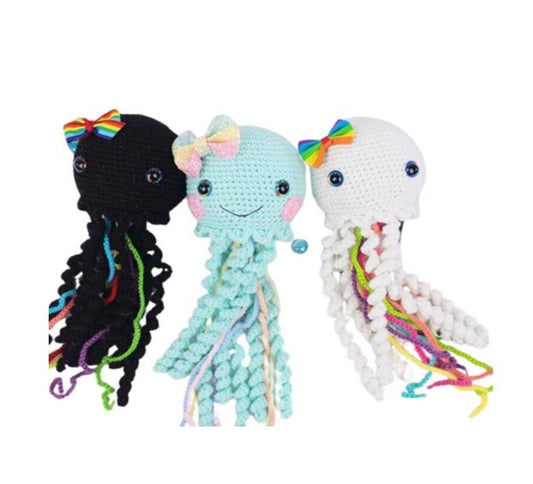 Set of three whimsical crochet amigurumi jellyfish with colorful tentacles and bows in black, light blue, and white designs.
