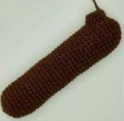 Brown crocheted amigurumi sausage dog body piece in progress against a plain background.