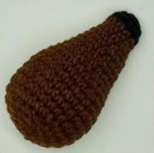 Small brown crochet amigurumi dachshund nose with black tip yarn detail.