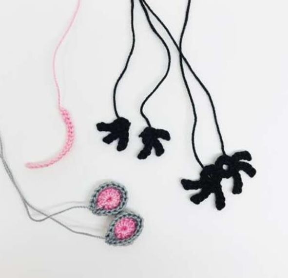 Unfinished Mouse King amigurumi crochet parts including ears and black limbs on white background.